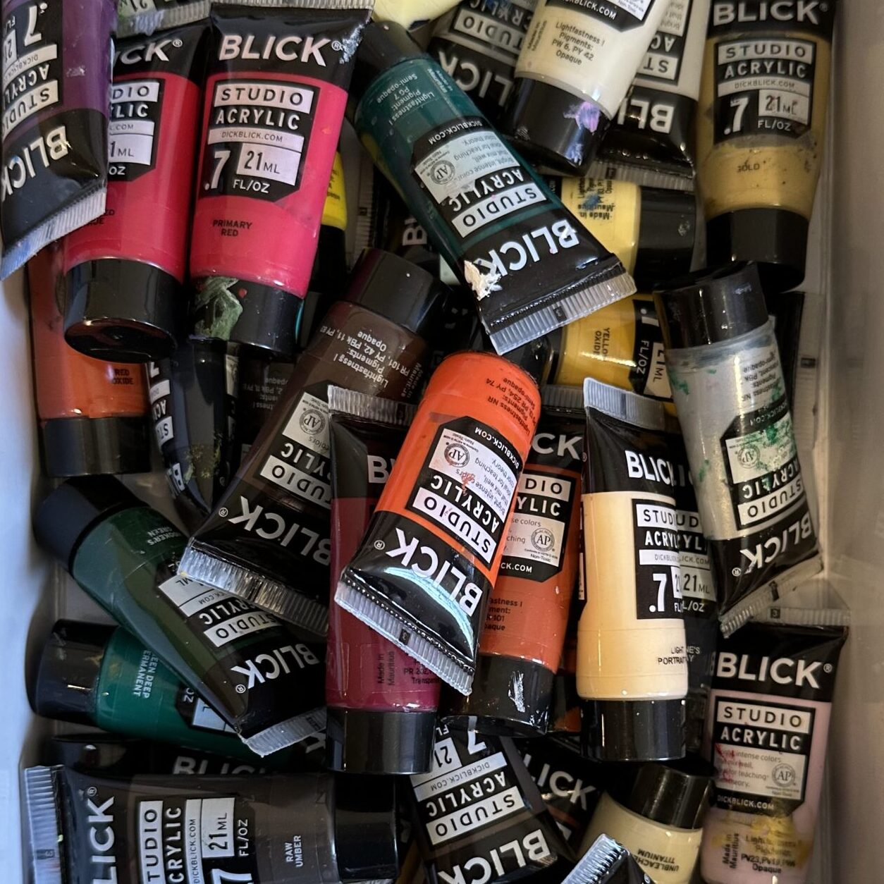 Collection of small tubes of acrylic paints in various colors.