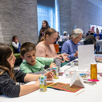 familes make art together at a table at a museum